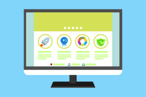 A computer monitor displays a website with four highlighted features, each represented by different icons: a rocket, a blue badge, a colorful star, and a green shield, set against a light blue background.